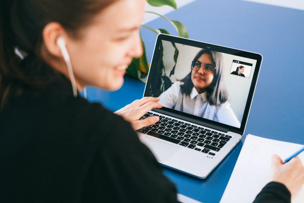 A woman on a video call, on her laptop, with another woman. 